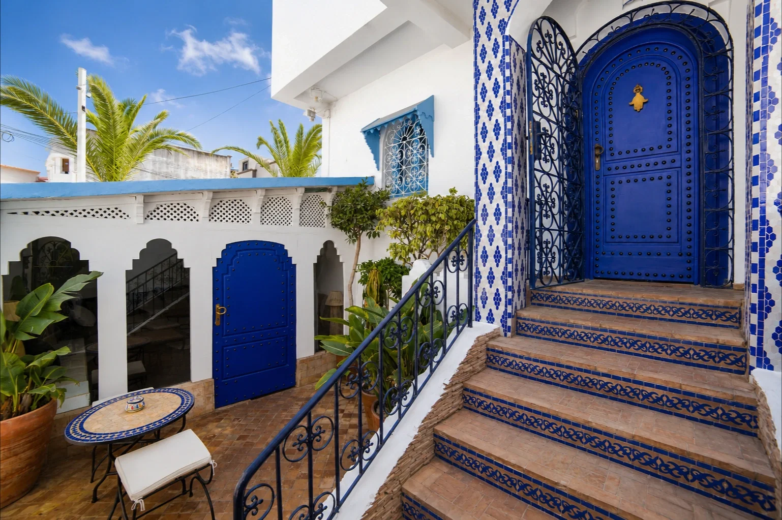 Puerta azul de la entrada y escalera con azulejos