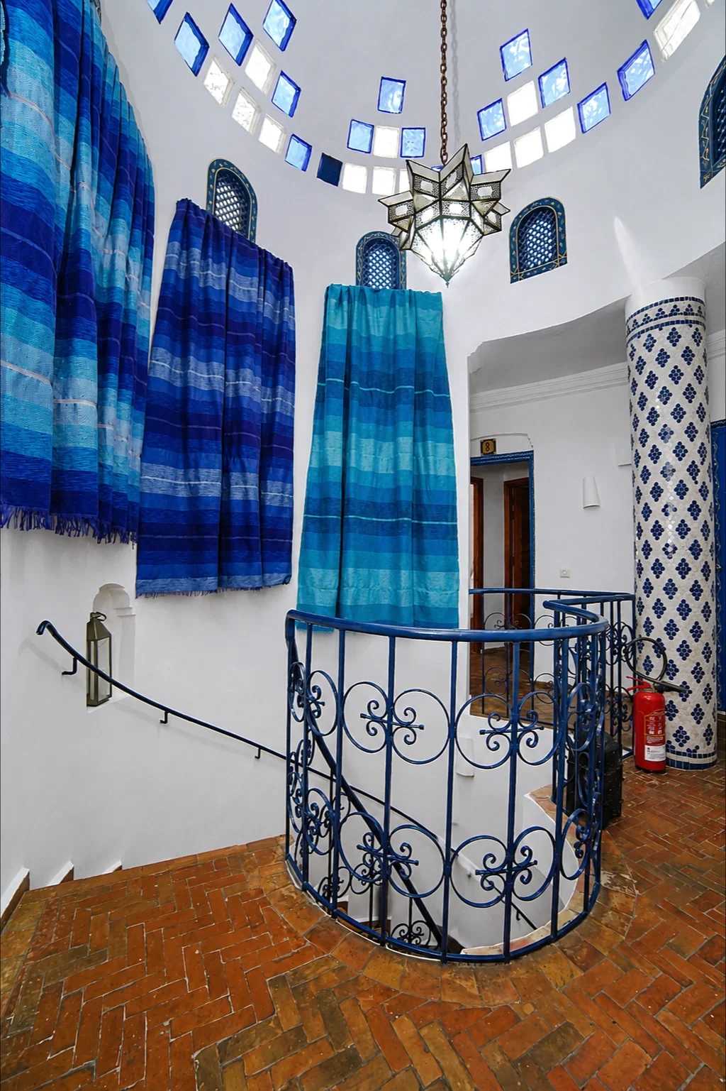 Escalera de caracol junto a columna de azulejos