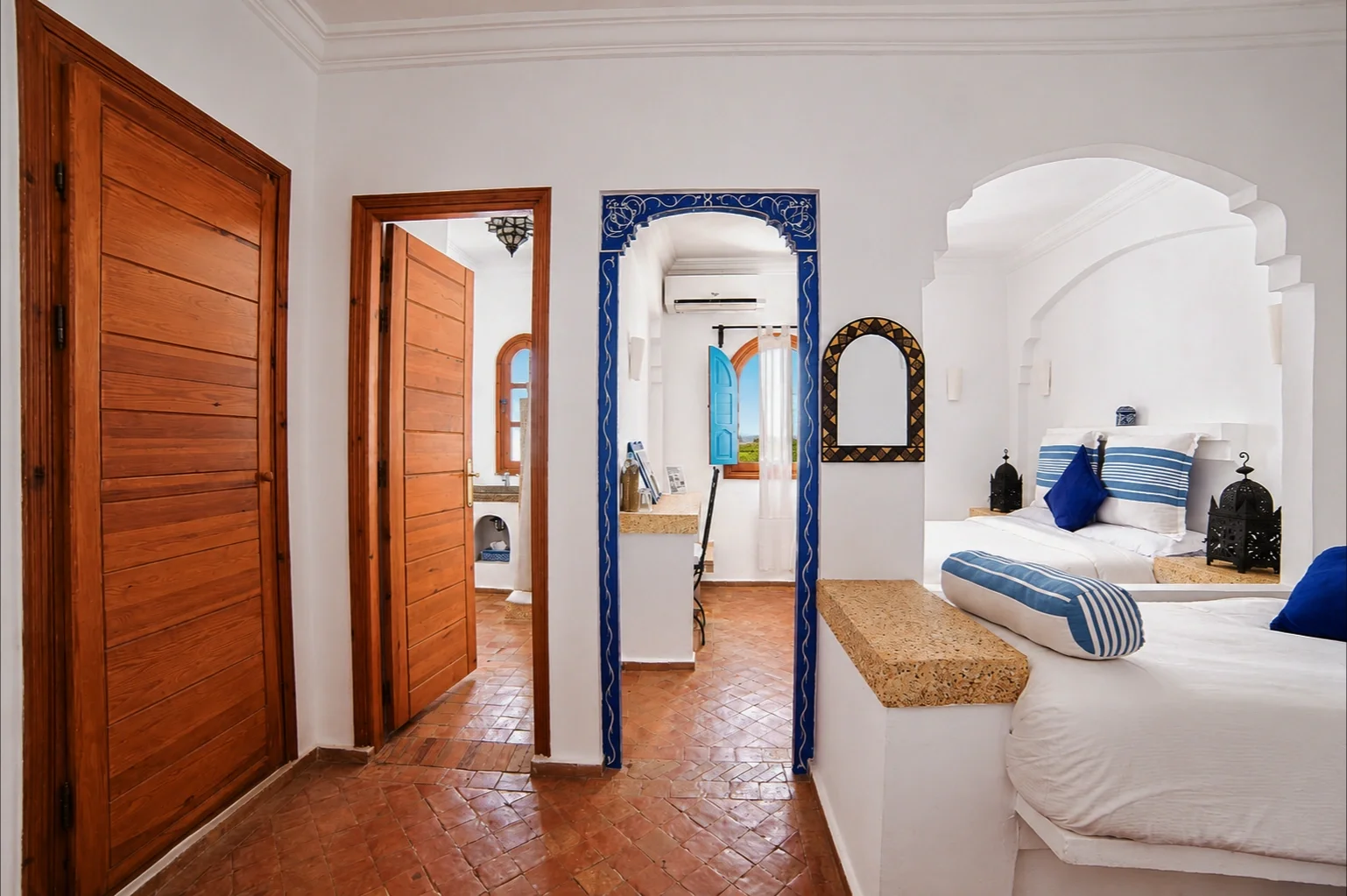 Pasillo con puertas de madera y arco de azulejos azules